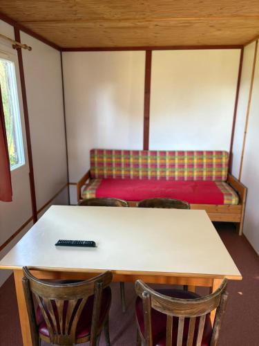 une pièce avec une table, des chaises et un lit dans l'établissement Chalet Aramis à la ferme, à Pouylebon
