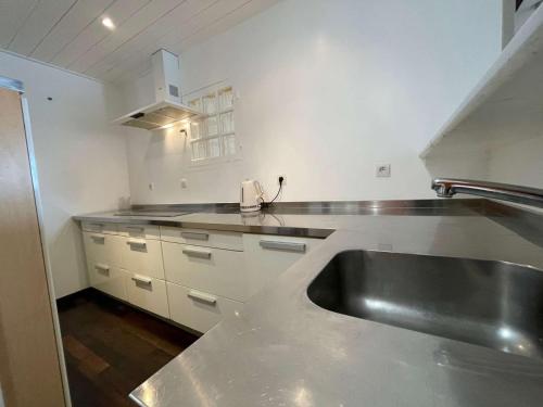 a kitchen with a stainless steel sink and white cabinets at Appt 3 pièces LA ROCHELLE - LR180-030 in La Rochelle