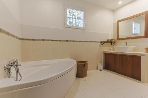 une salle de bain blanche avec une baignoire et un lavabo dans l'établissement Source de Vie, à Noves