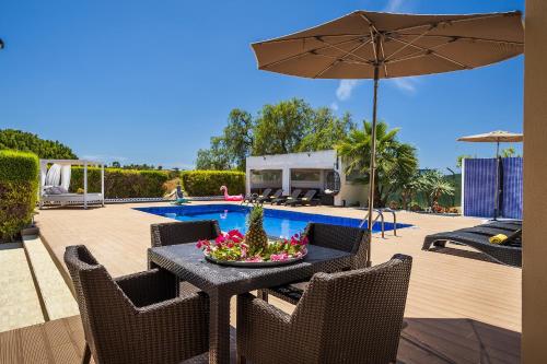 a table and chairs with an umbrella next to a pool at Loendros, Calma Moradia com Piscina Privada, Guia in Guia
