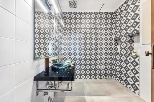 a bathroom with a black counter and a tile wall at Loendros, Calma Moradia com Piscina Privada, Guia in Guia