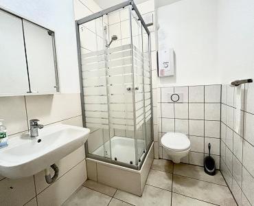 a bathroom with a shower and a sink and a toilet at Apart Residence KK in Glinde