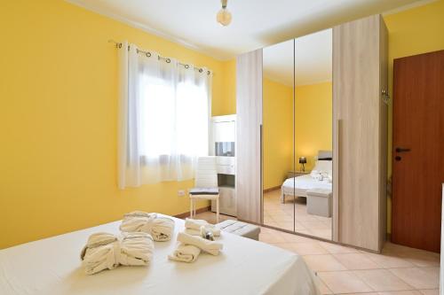 a bedroom with yellow walls and a bed with towels at Tiria, apartamento 2 habitaciones in Tergu