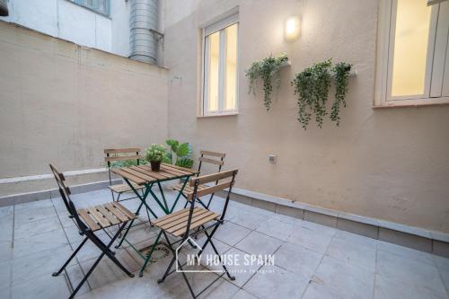 stół i krzesła z roślinami na ścianie w obiekcie MyHouseSpain - Acogedor piso con patio en Chamberi w Madrycie