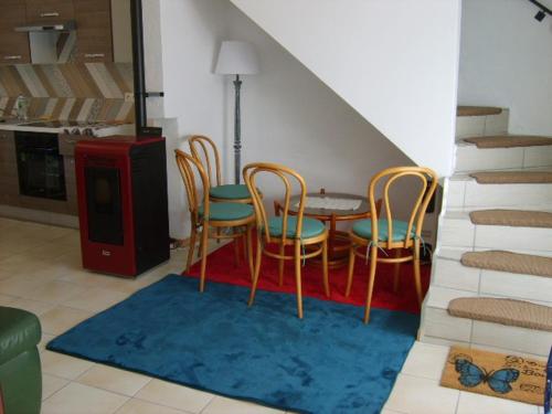 - une salle à manger avec des chaises, une table et des escaliers dans l'établissement Gîte dans un village médiéval, à Auzon