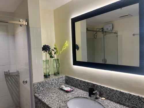 un baño con lavabo y espejo en Accolade Place 216, en Manila