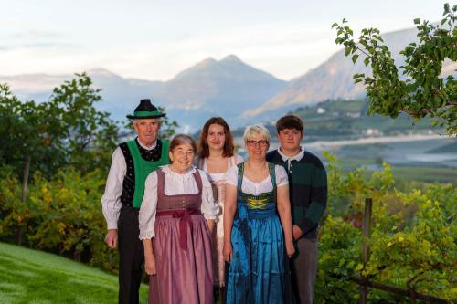 a family posing for a picture with mountains in the background at Petaunerhof in Schenna