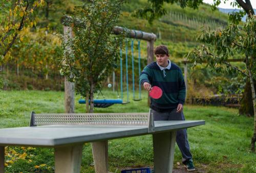 a man throwing a red frisbee at a table at Petaunerhof in Schenna