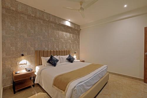 a bedroom with a large bed and a night stand at Hotel Grand Continent Gachibowli - US Consulate in Gachibowli