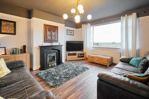 un salon avec un canapé et une cheminée dans l'établissement Host & Stay - By The Sea, à Newbiggin-by-the-Sea