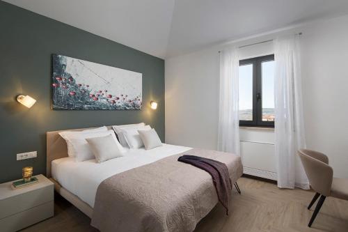 een slaapkamer met een groot wit bed en een raam bij Luxury villa Arman with whirlpool in Visinada in Vranje Selo