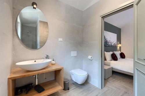 een badkamer met een wastafel en een spiegel en een bed bij Luxury villa Arman with whirlpool in Visinada in Vranje Selo