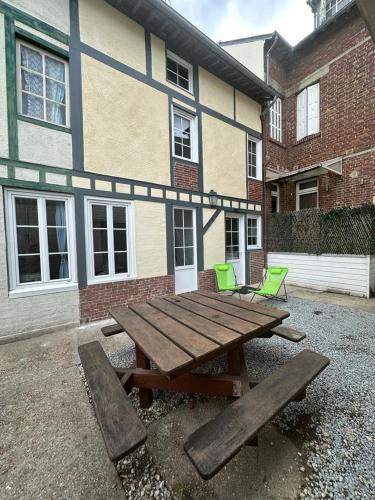 une table de pique-nique en bois devant un bâtiment dans l'établissement Petite maison place du marché, à Deauville