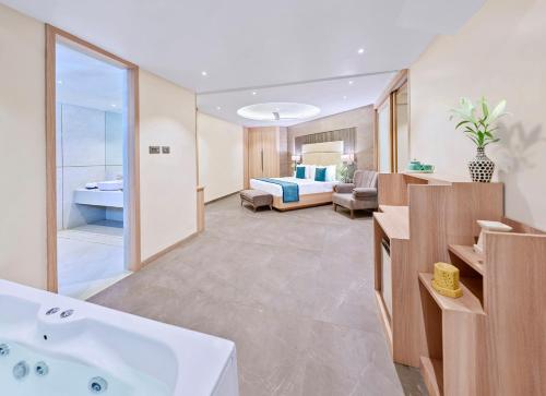 a bathroom with a bath tub and a bedroom at Shivsagar Resort & Spa in Mahabaleshwar