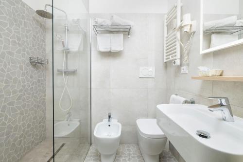 a bathroom with a toilet and a sink and a shower at Hotel Marco Polo in Caorle