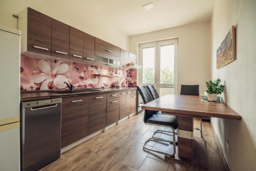 a kitchen with a wooden table and a dining room at Škodova Apartments in Přerov