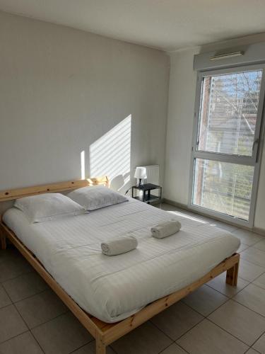 une chambre avec un grand lit avec deux oreillers dessus dans l'établissement Ilot Verde - Premiere conciergerie, à Montpellier