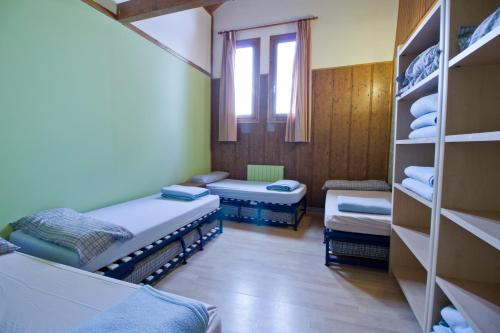 a room with two beds and a window and shelves at Valle de Aísa in Aísa