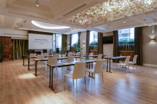 a conference room with tables and chairs and a screen at Hotel Fenix Gran Meliá - The Leading Hotels of the World in Madrid