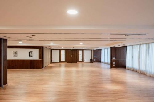 a large room with a wooden floor and windows at Hotel Don Pepe Gran Meliá in Marbella