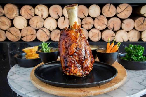 a piece of meat on a plate on a table at Hotel Don Pepe Gran Meliá in Marbella