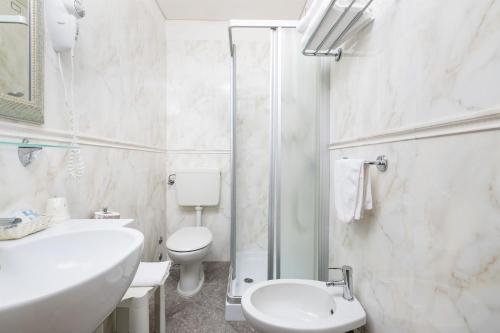 a bathroom with a toilet and a sink and a shower at Hotel Marco Polo in Caorle