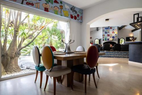 une salle à manger avec une table et des chaises et une grande fenêtre dans l'établissement Villa Reninca - Côte D'Azur, à Saint-Tropez
