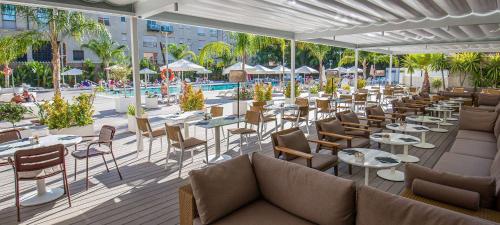 a restaurant with tables and chairs and a pool at Melia Lebreros in Seville