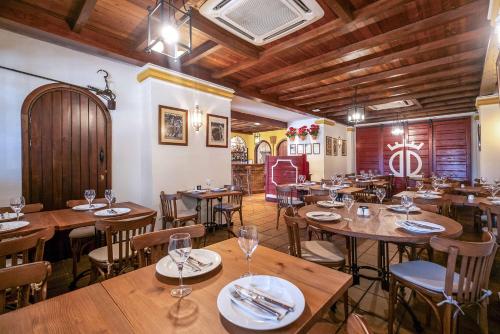a restaurant with wooden tables and chairs and wooden ceilings at Melia Lebreros in Seville