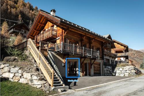 a man standing on the roof of a log cabin at Studio cosy dans chalet in Abriès