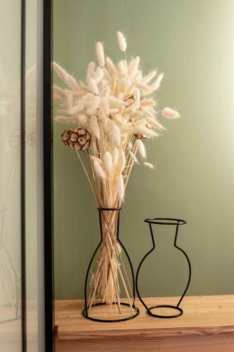 a vase with white flowers in it on a table at Studio cosy dans chalet in Abriès