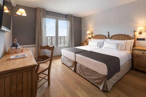 a hotel room with a large bed and a desk at Melia Sierra Nevada in Sierra Nevada
