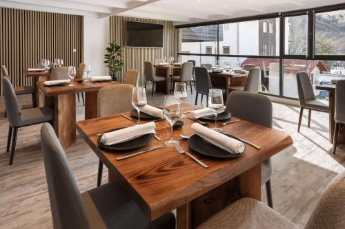 a dining room with wooden tables and chairs at Melia Sierra Nevada in Sierra Nevada