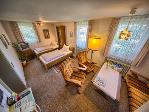 een woonkamer met een bed en stoelen bij Ferienwohnung Kaltenbach in Schonach