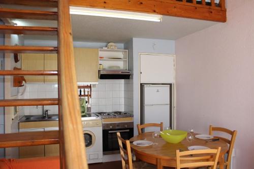 une cuisine avec une table et une cuisine avec une cuisinière dans l'établissement SP200-056 Maison 3 pièces mezzanine SAINT PIERRE LA MER, à Saint Pierre La Mer