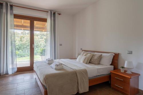 フォッサチェージアにあるVilla Mura - YourPlace Abruzzoの大きなベッドと大きな窓のある寝室