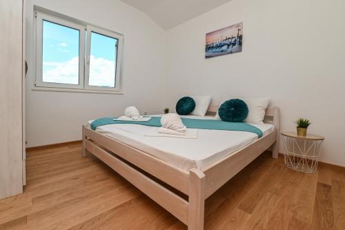 a bedroom with a bed with blue sheets and a window at Holiday home Viva in Gajac