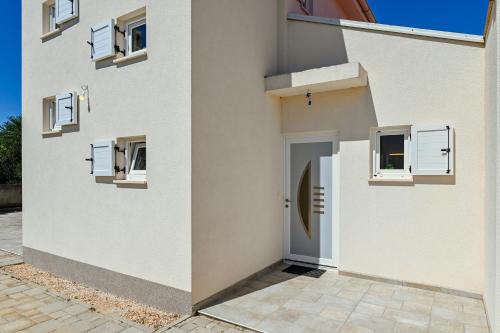 a white house with a door and windows at Holiday home Viva in Gajac