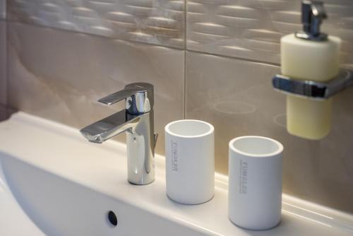 a bathroom sink with two cups and a faucet at Holiday home Viva in Gajac