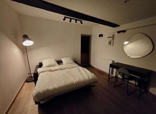 une chambre avec un lit, un miroir et un bureau dans l'établissement Studio cosy centre ville, à Besançon