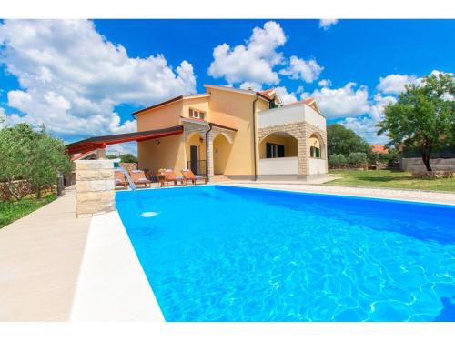 a villa with a swimming pool in front of a house at Villa Pletikosa in Brištane