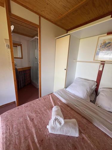 une chambre avec un lit avec une serviette dessus dans l'établissement Chalet PORTHOS à la ferme, à Pouylebon