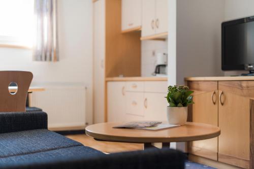 a living room with a table and a tv at Petaunerhof in Schenna