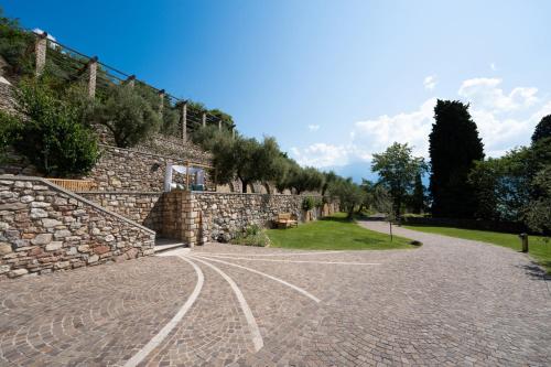 a stone wall next to a brick road at Luxury Villa with Private Pool and Lake View in Gargnano