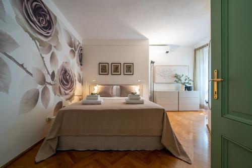 a bedroom with a bed with a flower mural on the wall at Luxury Villa with Private Pool and Lake View in Gargnano