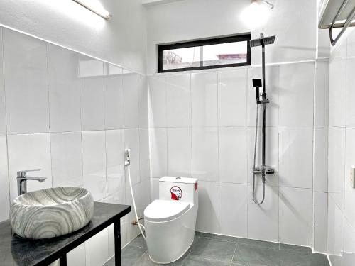 a white bathroom with a toilet and a shower at Noi Bai Sunflower Hotel in Noi Bai