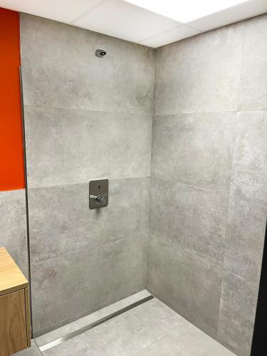 a shower in a bathroom with a wall at Erlebniswelt Resort Apartment 10 in Reken