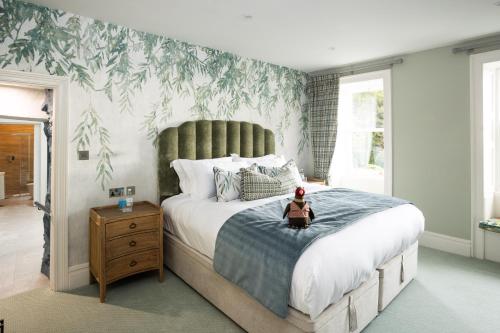 a bedroom with a large bed with a green leaf wallpaper at Aynsome Manor in Cartmel