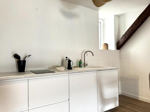 une cuisine avec des armoires blanches et un évier dans l'établissement ღ Bubble Loft - Bain Balnéo, spacieux en centre ville, à Nantes