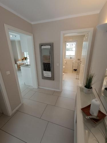 a white bathroom with a sink and a mirror at Haus Nemo - Appartement 5, Gemütliches Appartement - Strandkorb, strandnah 50 m in Heringsdorf